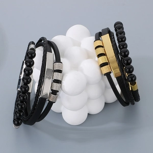 Detail of layered leather bracelet with magnetic clasp and decorative metal charms