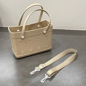 Detail of beige EVA beach bag with holes showing the adjustable fabric shoulder strap