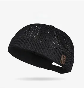 Detail of breathable black mesh docker hat featuring brown leather label and adjustable strap