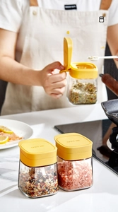 Close-up of glass spice jar with yellow flip lid and printed Spice Jar text