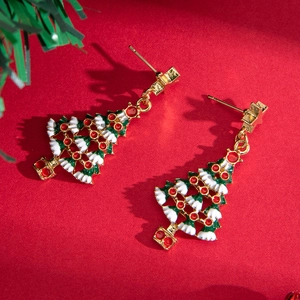 Enamel Christmas tree earrings with star and gift box on a festive red background