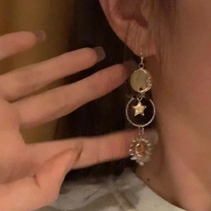 Detailed close-up of a vintage celestial earring with sun moon and star pendants
