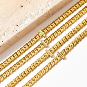 Gold snake chain necklaces with T-bar clasps and colorful crystal stones on marble base