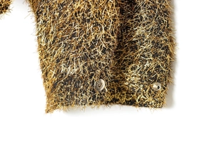 Detail of metallic bomber jacket with gold thread texture and silver snap buttons