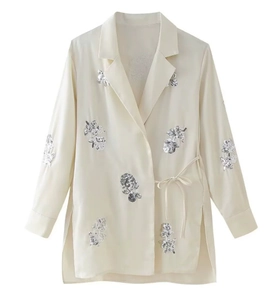 Detail der beige Satin-Hemdjacke mit silbernen Paillettenblumen und seitlichem Kordelzug-Design