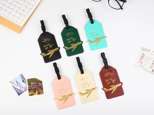 Flat lay of colorful faux leather airplane luggage tags with gold accents in six colors