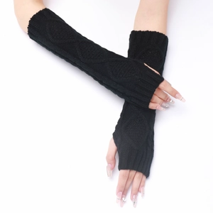 Close-up of black cable-knit arm warmers with diamond texture and fingerless design