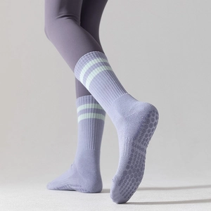 Detail of purple yoga toe socks with non-slip grips and green stripes on the heel