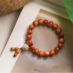 Close-up of dark rosewood prayer beads featuring a cute white cat paw pendant charm
