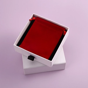 Top view of white drawer paper box set with red velvet drawstring jewelry storage pouch