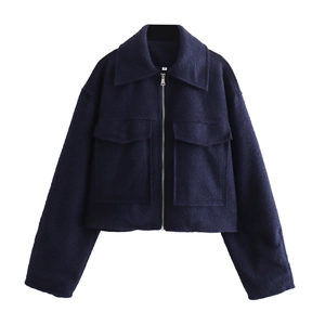 Détail de veste courte bleu marine avec poches à rabat et fermeture à glissière métallique
