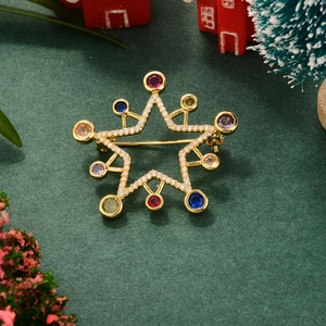 Macro shot of gold star brooch with colorful rhinestones on festive Christmas background