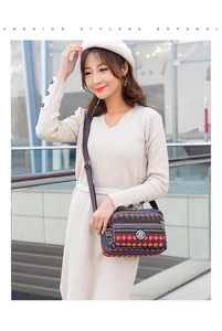 Ethnic striped canvas crossbody bag with adjustable strap worn by a model in casual style