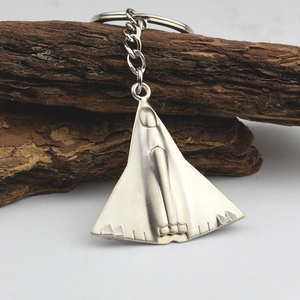Zilveren metalen J-35 gevechtsvliegtuig sleutelhanger met ketting op houten voet