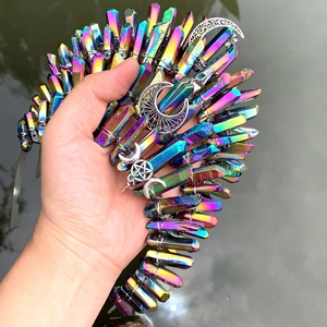 Handheld rainbow crystal crown headband with silver moon and star charms by the water