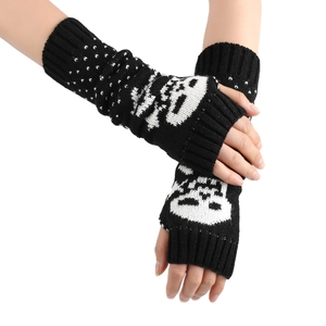 Close-up of black fingerless knit arm warmers with white skull and polka dot patterns