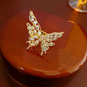 Macro shot of gold-plated butterfly ring featuring white pearls and zircon accents