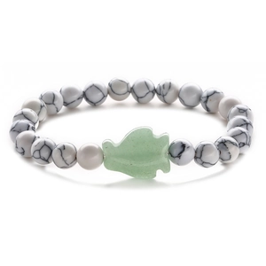 Detail of white marble textured beads and green leaf charm on a stretch bracelet