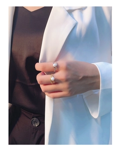 Close-up of gold and silver crossover rings with pearls on a female model's hand