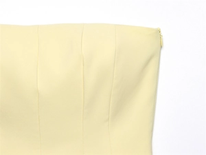 Close-up of yellow strapless top showing invisible side zipper and precise stitching
