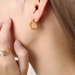 Gold irregular geometric earrings and heart zircon ring on model for a trendy look