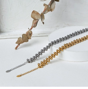 Close-up of gold and silver beaded multilayer bracelets with adjustable chains