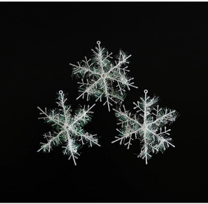 Detailed view of three white snowflake ornaments with iridescent glitter for Christmas tree