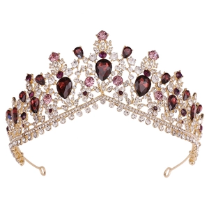 Close-up of luxury bridal crown with deep red crystals and rhinestones on gold base