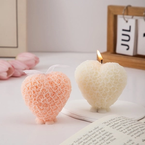 Detail view of pink and white heart-shaped rose candles on a cozy aesthetic desk