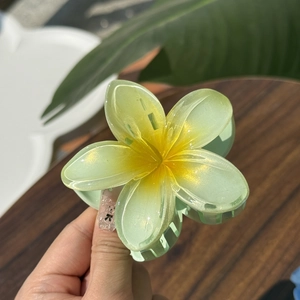 Macro detail of Frangipani hair claw clip showing gradient green petals and glitter texture