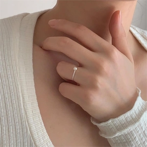 Minimalist S925 sterling silver pearl ring shown on finger with delicate knitwear