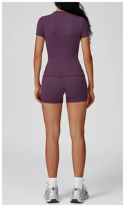 Rear view of purple seamless yoga set showing fitted short sleeve top and high waist shorts