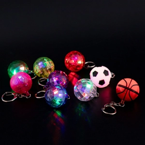 Close-up of glowing LED disco ball keychains in football and basketball shapes