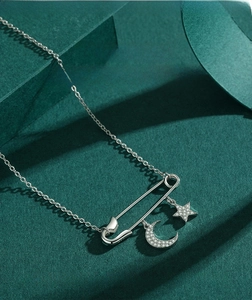 Detailed shot of S925 sterling silver safety pin necklace with moon and star pendants