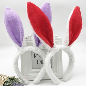 Detail of plush white bunny ear headbands in red and purple colors for festive parties