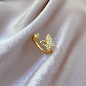 Golden butterfly open ring with sparkling crystal inlay on elegant silk background