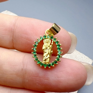 Golden Jesus pendant with green zircon stones showing detailed craftsmanship