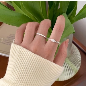 Detail of silver twisted chain ring with square zircon and hammered minimalist band