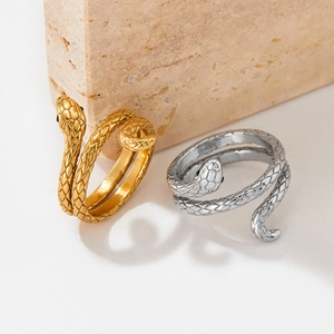 Bagues serpent en acier doré et argenté avec texture d'écailles sur fond de pierre