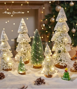 Mini snowy Christmas trees with LED lights and natural wood bases on a cozy table