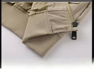 Makro-Detail einer khakifarbenen Fliegerjacke mit Rippbündchen und Metallreißverschluss