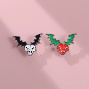 Detail of bat-winged skull enamel pins in black-white and red-green color variants