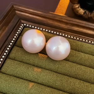 Close-up of premium round pink pearls with high luster inside a vintage green jewelry box