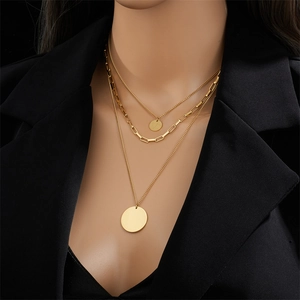 Three-layer gold titanium steel necklace with circular pendants on a model in a black blazer