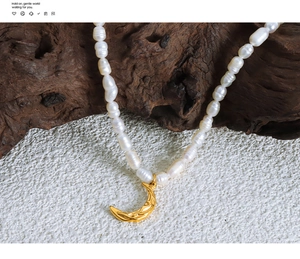 Macro detail of hammered crescent moon pendant and baroque freshwater pearl necklace