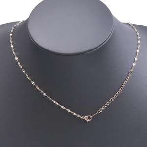 Close-up of rose gold stainless steel lip chain necklace on black jewelry display stand