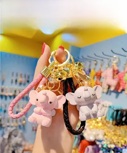 Cute cartoon elephant keychain with crown and woven lanyard held in hand
