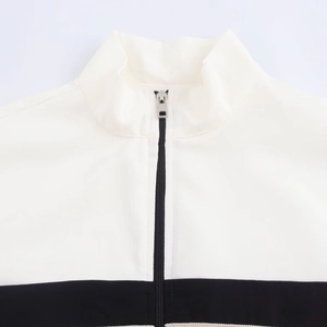 Detail of white stand collar jacket with black zipper and contrast panel stitching