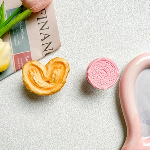 Detail of cute heart-shaped biscuit and pink 'LOVE' cookie phone grip on white background