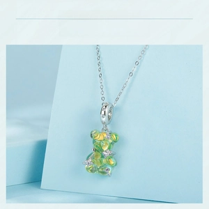 Detailed view of s925 silver bear pendant with green resin and crystal stars detail